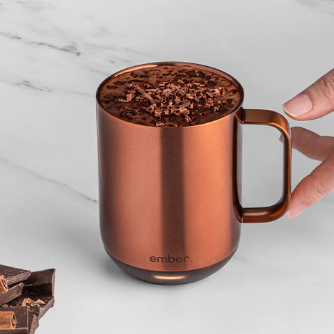 A Copper Ember Mug² is filled to the top with a decadent chocolate drink.
